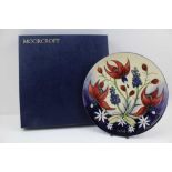 A MOORCROFT POTTERY PLATE, tube lined and hand-painted with design of fuchsias and bluebells,