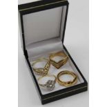 A SELECTION OF FIVE RINGS comprising; an 18ct gold buckle form ring, together with; a 9ct gold