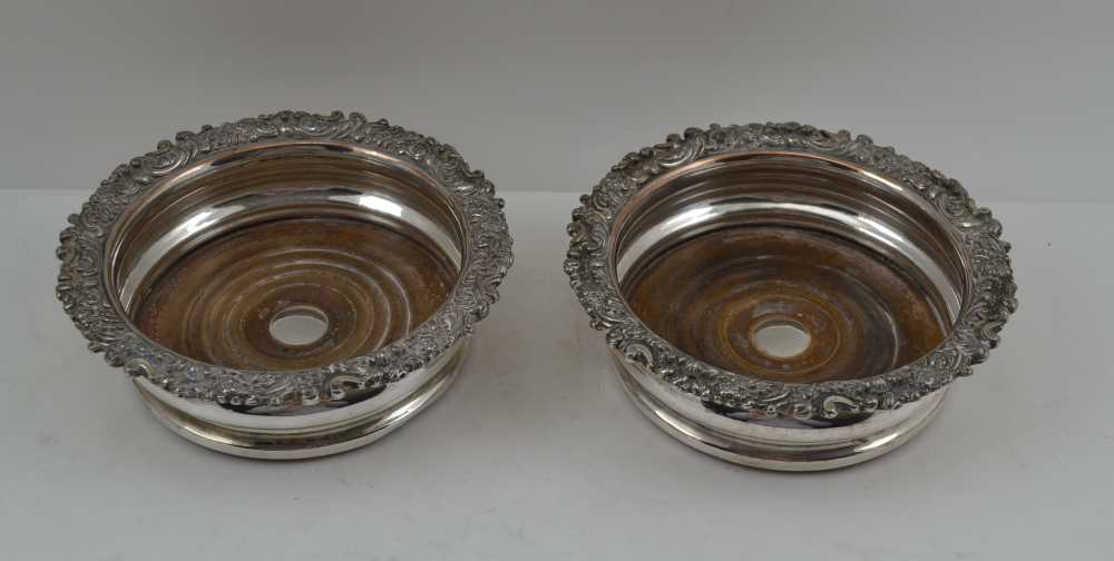 A PAIR OF SILVER PLATED BOTTLE COASTERS, Sheffield c1820, on turned wood bases, 16cm in diameter