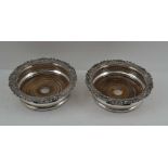 A PAIR OF SILVER PLATED BOTTLE COASTERS, Sheffield c1820, on turned wood bases, 16cm in diameter