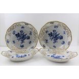 A PAIR OF SCHUMANN PORCELAIN BOWLS, with reticulated gilded rims, blue rose decoration to the soles,