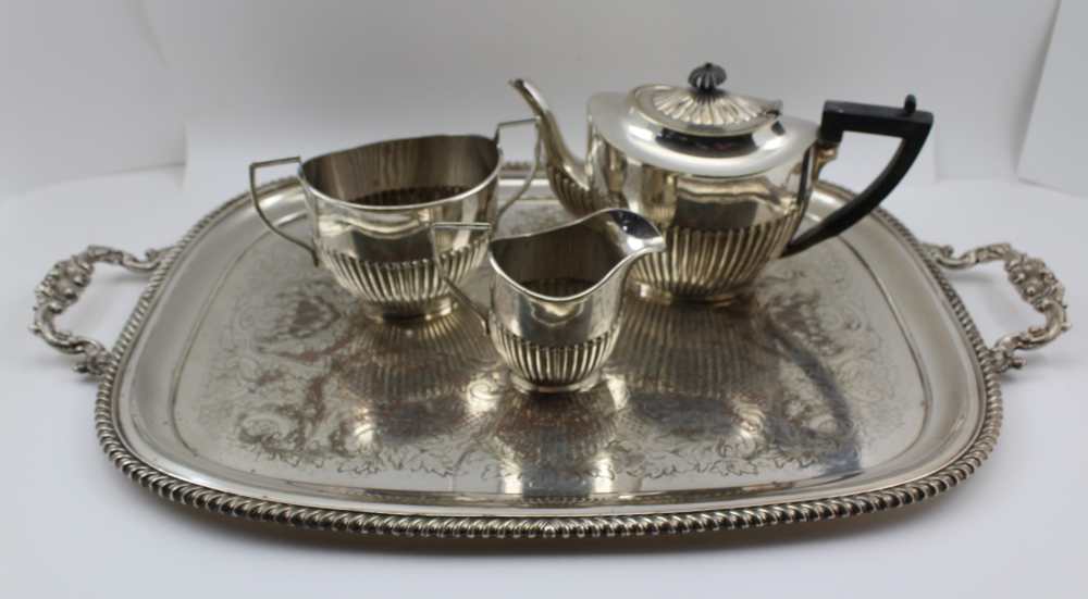 AN EARLY 20TH CENTURY SILVER-PLATED TRAY with cast handles together with a three piece half fluted
