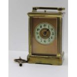 A BRASS FRAMED CARRIAGE CLOCK, c.1900 with bevelled glass panels, circular dial with Arabic