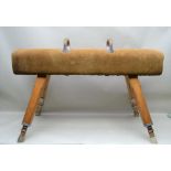 A MID-20TH CENTURY VAULTING POMMEL HORSE in brown suede, raised on adjustable splayed legs, 1m wide
