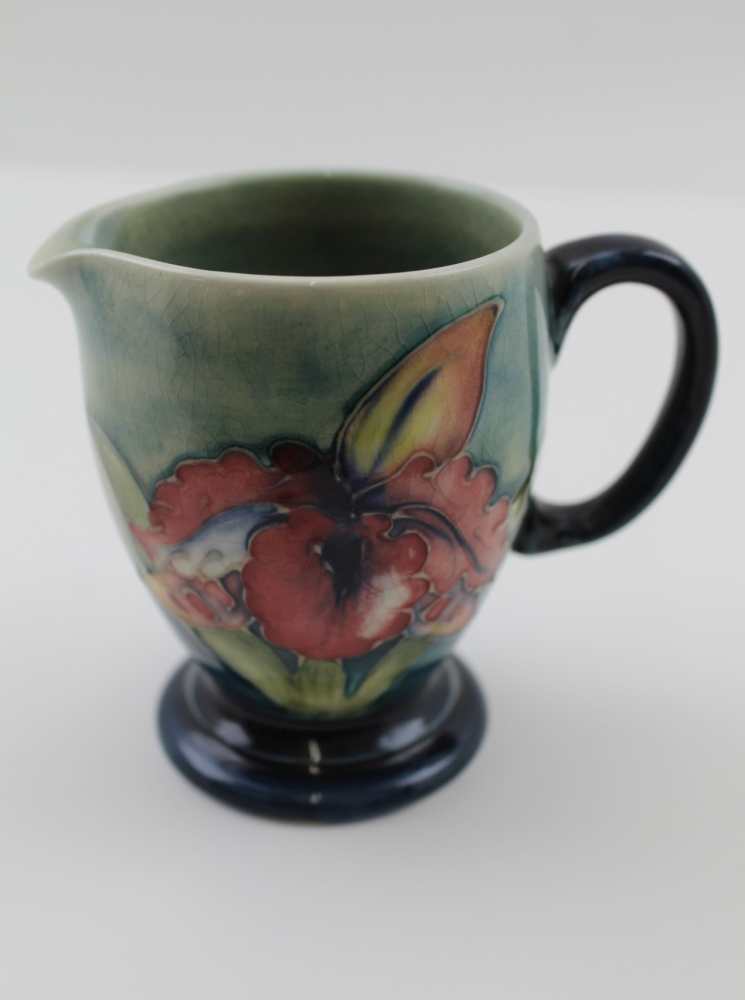 A MOORCROFT POTTERY CREAM JUG, tube lined and painted, orchid design, factory impressed marks to