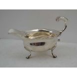 SAMUEL MERITON A GEORGE II SILVER SAUCE BOAT, London 1754, on three supports with scroll handle,