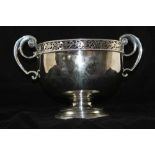 A SILVER PLATED BOWL with pierced rim and scroll terminal handles on circular platform foot, 23cm