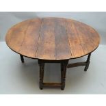 A LATE 18TH / EARLY 19TH CENTURY OAK TWIN FLAP DINING TABLE having single gateleg action,