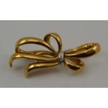 AN ITALIAN 18K BROOCH of tied bow design, inset three brilliant cut diamonds, 7cm, 21g