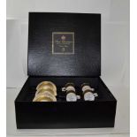 A ROYAL WORCESTER CLIVE CHRISTIAN CERAMIC PRESENTATION BOX OF FOUR COFFEE CANS & SAUCERS, gilded "