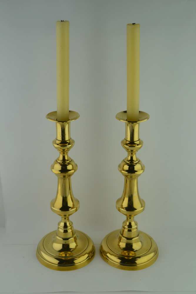 A PAIR OF LATE VICTORIAN BRASS CANDLESTICKS, with pushrods, on domed circular bases, 31cm high