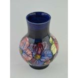 A MOORCROFT CLEMATIS PATTERN POTTERY VASE, tube lined and painted decoration on a cobalt blue ground