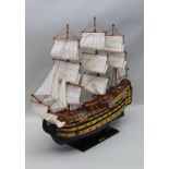 A RIGGED MODEL OF "HMS VICTORY", painted wood and canvas sails, on plinth base bearing a brass