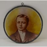 AN EDWARDIAN PAINTED GLASS PANEL, a portrait of a gentleman, circular panel with lead frame and