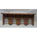 AN OAK NEO-GOTHIC DESIGN WALL SHELF, with arcaded frieze, cross motif to central lower section, 76cm