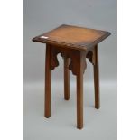 AN EDWARDIAN OAK OCCASIONAL TABLE, raised on squared supports, the squared top; 30cm, 48cm high