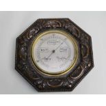 AN EARLY 20TH CENTURY WALL BAROMETER, mounted in an octaganol carved oak frame, with silvered