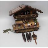 A SWISS CUCKOO CLOCK, of chalet form with various automation, having three cast metal pine cone