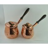 TWO EARLY 19TH CENTURY COPPER PANS, with covers and turned wood side handles, the largest 12cm high