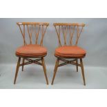 A PAIR OF "ERCOL" STICK BACK SINGLE CHAIRS, one still bears the paper label to the back of the seat