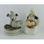 A 19TH CENTURY POTTERY INKWELL in the form of a swan beside her nest, 10cm high, together with a