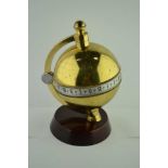 A "CHARLES FRODSHAM" BRASS GLOBE FORM TABLE CLOCK, banded by a silvered chapter ring with Roman