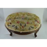 AN OVAL FOOTSTOOL, carved wood frame with cabriole feet, the oval top upholstered with a