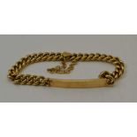 A YELLOW METAL IDENTITY BRACELET, various stamp marks to clasp, fitted safety chain, weight; 43g