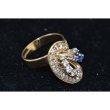 A 1970's 9CT GOLD DIAMOND AND SAPPHIRE DESIGNER DRESS RING, set with three sapphires, twenty old