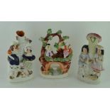 A 19TH CENTURY STAFFORDSHIRE POTTERY SPILL HOLDER moulded with two figures standing beside a tree,
