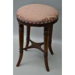 A LATE VICTORIAN MAHOGANY FRAMED STOOL, raised on ring turned supports with outswept feet, with