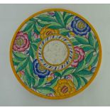 A CHARLOTTE RHEAD POTTERY CHARGER, mottled ground, painted with a floral border and yellow edge,