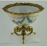 A CONTINENTAL PORCELAIN BOWL, hand painted floral swags with gilding, cast brass rim, raised on