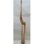A MID 20TH CENTURY HAND CARVED FREE-STANDING GIRAFFE, fashioned from a single trunk, 188cm high (