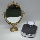 A DECORATIVE BRASS FRAMED DRESSING TABLE MIRROR, oval plate, 34cm x 26cm, set in a swinging frame on