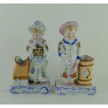 A PAIR OF LATE 19TH CENTURY CONTINENTAL CERAMIC VESTA HOLDERS, modelled as children with luggage,