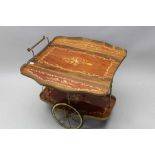 A TWO TIER DRINKS TROLLEY, marquetry effect decoration, with brass gallery, brass framed wheels