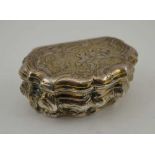AN 18TH CENTURY PARCEL GILT WHITE METAL CONTINENTAL SNUFF BOX, of Rococo serpentine form, repousse