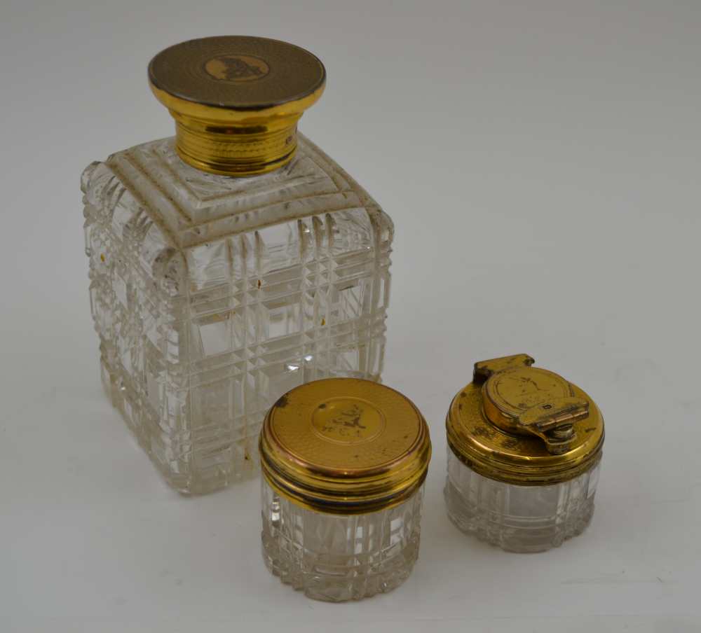 THOMAS DILLER THREE CUT GLASS APPOINTMENTS WITH SILVER GILT LIDS, a toilet water bottle, a rouge jar