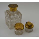 THOMAS DILLER THREE CUT GLASS APPOINTMENTS WITH SILVER GILT LIDS, a toilet water bottle, a rouge jar