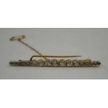 A GRADUATED DIAMOND SET BAR BROOCH, seventeen brilliant cut diamonds in a gold setting, with