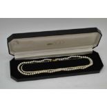 A CULTURED PEARL SINGLE STRAND NECKLACE with 9ct gold clasp, 44cm long, together with a SIMULATED