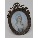 AN 18TH CENTURY PORTRAIT MINIATURE of a lady, inscribed 'Cosway 1787', in an ornate brass frame, 9cm