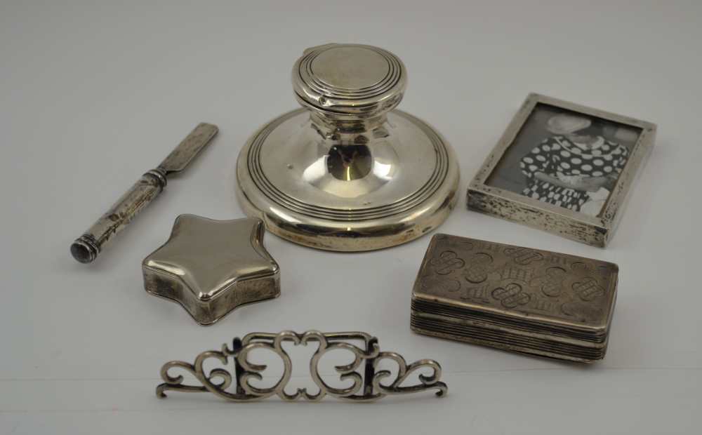 A COLLECTION OF SILVER ITEMS comprising; a silver menu holder, a small silver photo frame, a capstan