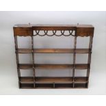 A GEORGIAN DESIGN OAK WALL RACK, having pierced decorative frieze, shaped sides, fitted shelves,