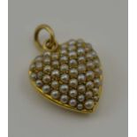 A VICTORIAN GOLD HEART FORM PENDANT LOCKET, inset seed pearls, glazed lenticel panel en verso,