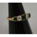 AN EMERALD AND DIAMOND RING, mounted with two brilliant cut diamonds and three cushion cut emeralds,