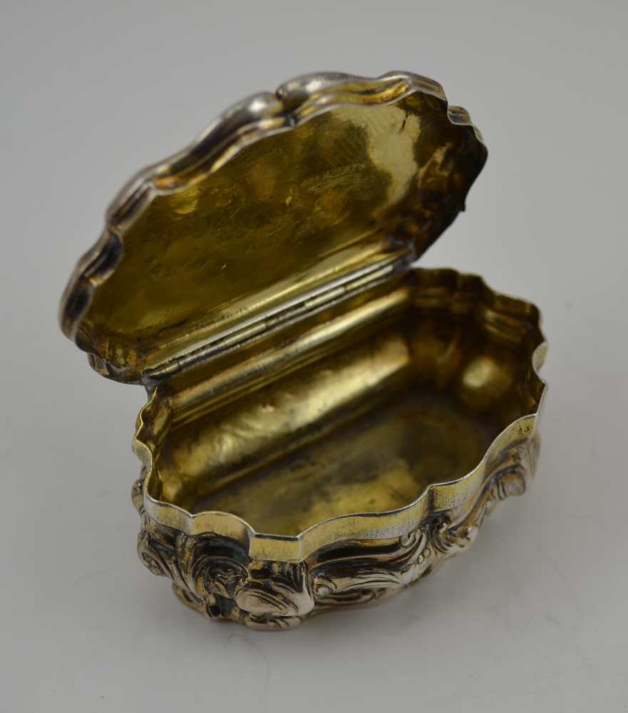 AN 18TH CENTURY PARCEL GILT WHITE METAL CONTINENTAL SNUFF BOX, of Rococo serpentine form, repousse - Image 5 of 5