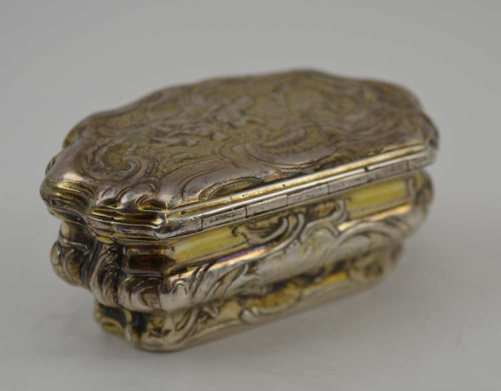 AN 18TH CENTURY PARCEL GILT WHITE METAL CONTINENTAL SNUFF BOX, of Rococo serpentine form, repousse - Image 3 of 5
