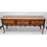A GEORGE III OAK DRESSER BASE, fitted three drawers, mahogany cross-banded with brass handles,